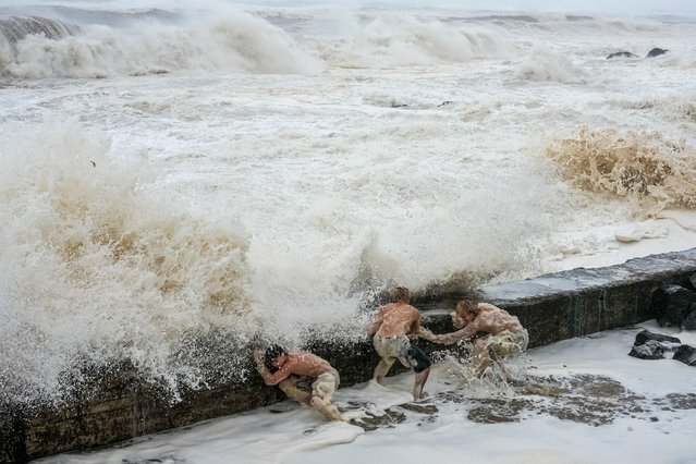 A group evade a crashing wave on March 07, 2025 in Tweed Heads, Australia. Australia's east coast, particularly Queensland and northern New South Wales, is bracing for the impact of Tropical Cyclone Alfred, a rare Category 2 storm that is expected to make landfall between the Gold Coast and southern parts of the Wide Bay region. The cyclone is anticipated to bring damaging winds, heavy rainfall, and severe flooding, with millions of residents preparing for the worst-case scenario. Authorities have issued evacuation orders, distributed sandbags, and shut down airports and public transport in anticipation of the storm's arrival, which could be one of the most significant weather events in the region in decades. (Photo by Asanka Ratnayake/Getty Images)