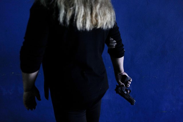 A resident who did not want to be identified shows the gun she keeps at her home for self-defense as she poses for a photo in Rosario, Argentina, Monday, April 8, 2024. (Photo by Natacha Pisarenko/AP Photo)