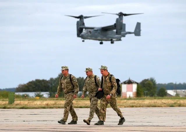 Ukrainian service members walk on the tarmac of an airfield during joint air drills conducted by Ukrainian and U.S. special operation military forces, as part of a broader cooperation aimed at enhancing interoperability between divisions, near Vinnytsia, Ukraine on September 18, 2020. (Photo by Gleb Garanich/Reuters)