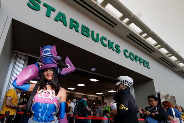 A costumed attendee is shown as others wait in line to get a coffee during the opening day of Comic-Con International in San Diego, California, on July 24, 2025. (Photo by Mike Blake/Reuters)