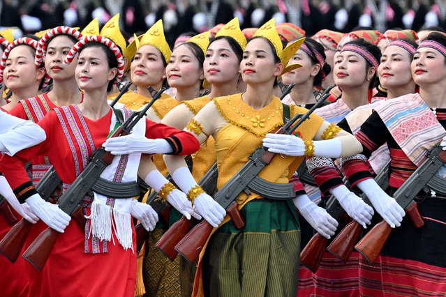 Women wearing Vietnamese national costumes take part in a National Day parade rehearsal in Hanoi on August 13, 2025, ahead of Vietnam's 80th National Day on September 2. (Photo by Nhac Nguyen/AFP Photo)