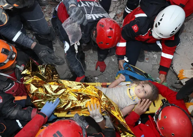 In this photo provided by the government's Search and Rescue agency AFAD, rescue workers, who were trying to reach survivors in the rubble of a collapsed building, surround Ayda Gezgin in the Turkish coastal city of Izmir, Turkey, Tuesday, November 3, 2020, after they have pulled the young girl out alive from the rubble of a collapsed apartment building four days after a strong earthquake hit Turkey and Greece. The girl, Ayda Gezgin, was seen being taken into an ambulance on Tuesday, wrapped in a thermal blanket, amid the sound of cheers and applause from rescue workers. (Photo by AFAD via AP Photo)