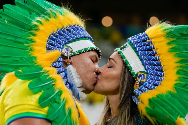 Brazil soccer team fans kiss ahead of the World Cup group G soccer match between Cameroon and Brazil, at the Lusail Stadium in Lusail, Qatar, Friday, December 2, 2022. (Photo by Frank Augstein/AP Photo)