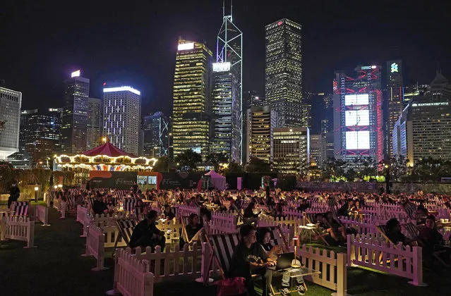 People watch a movie in an outdoor park in Hong Kong Tuesday, November 10, 2020. Hong Kong's first socially-distanced outdoor entertainment park opened its doors to public on Tuesday, as the events and entertainment industry adjusts to the coronavirus pandemic. (Photo by Vincent Yu/AP Photo)