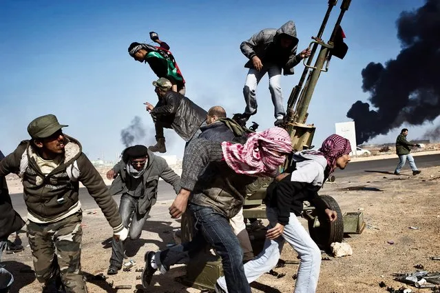 Rebels flee under fire from the Libyan army in Ras Lanuf, Libya, in March 2011. (Photo by Yuri Kozyrev/Noor Photo)