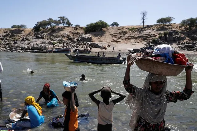 Refugees stand on the Ethiopian bank of a river that separates Sudan from Ethiopia near the Hamdeyat refugees transit camp, which houses Ethiopian refugees fleeing the fighting in the Tigray region, on the Sudan-Ethiopia border, Sudan, November 30, 2020. (Photo by Baz Ratner/Reuters)
