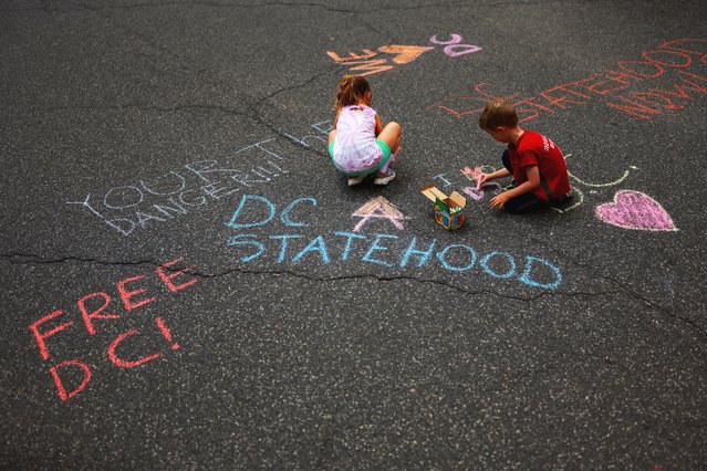 Children play with chalk, near personal messages written on the pavement, near the US District Court for the District of Columbia,  in Washington, on August 15, 2025. (Photo by Jose Luis Gonzalez/Reuters)