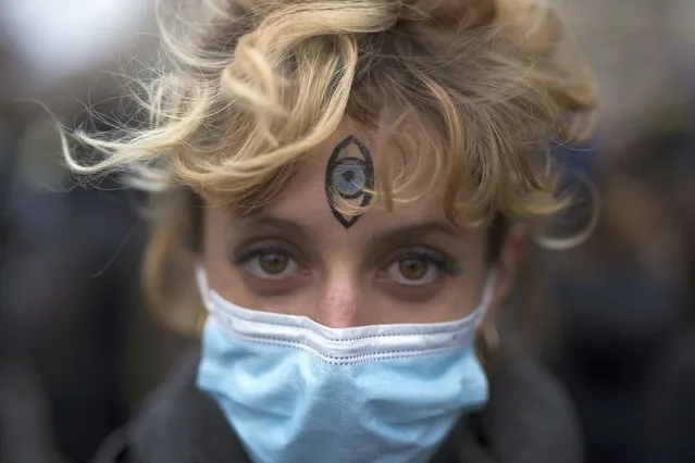 A protester with an eye painted on her forehead poses for a portrait during a demonstration, in Marseille, southern France, Saturday, December 5, 2020. (Photo by Daniel Cole/AP Photo)