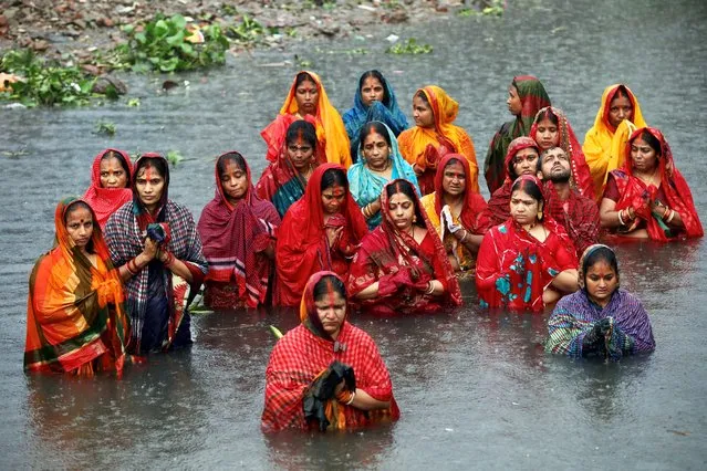 Hindu devotees stand in the water of the Buriganga river during rain as they observe Chhath Puja festival in Dhaka, Bangladesh, November 20, 2020. (Photo by Mohammad Ponir Hossain/Reuters)