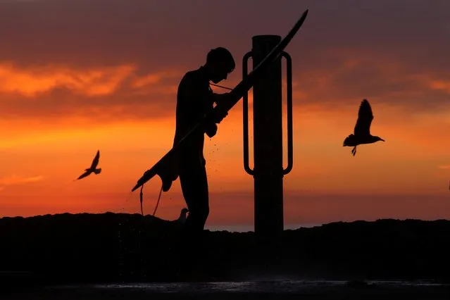 A surfer rinses off at an outdoor shower after leaving the ocean during the outbreak of the coronavirus disease (COVID-19) in Encinitas, California, U.S., December 9, 2020. (Photo by Mike Blake/Reuters)