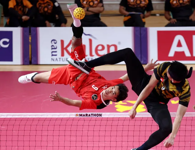 Malaysia's Muhammad Noraizat Mohd Nordin in action with Indonesia's Rusdi Rusdi in the Southeast Asian Games Sepak Takraw Final at Basketball Hall NSTC in Phnom Penh, Cambodia on May 16, 2023. (Photo by Chalinee Thirasupa/Reuters)