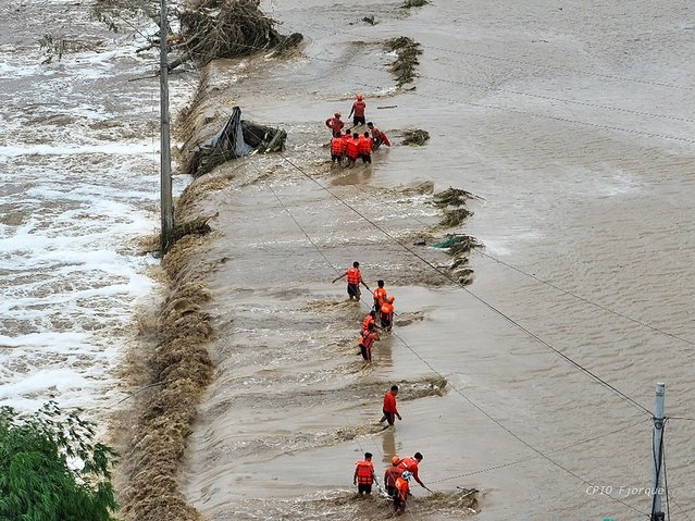This aerial handout photo taken on November 10, 2025 and released by the Cagayan Provincial Information Office shows rescuers making their way through floodwaters to reach flooded homes at a village in Tuao, Cagayan province, after a river overflowed due to heavy rains brought by Super Typhoon Fung-wong. Entire villages lay submerged and scores of towns remained without electricity on November 10 as Typhoon Fung-wong left the Philippines after killing at least two people and displacing more than a million. (Photo by Handout/Cagayan Provincial Information Office (PIO)/AFP Photo)