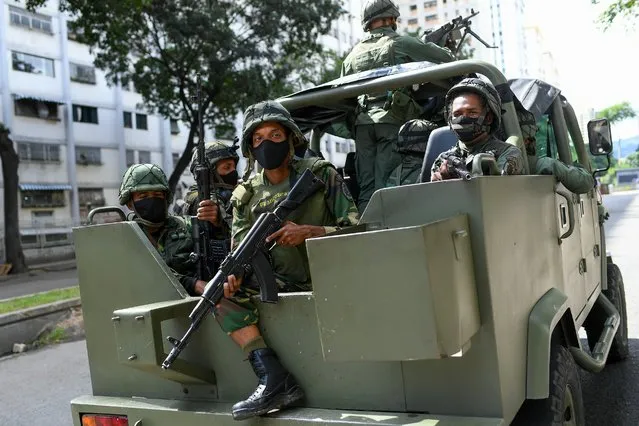 Soldiers patrol on a military vehicle during elections to choose members of the National Assembly in Caracas, Venezuela, Sunday, December 6, 2020. The vote, championed by President Nicolas Maduro is rejected as fraud by the nation's most influential opposition politicians. (Photo by Matias Delacroix/AP Photo)