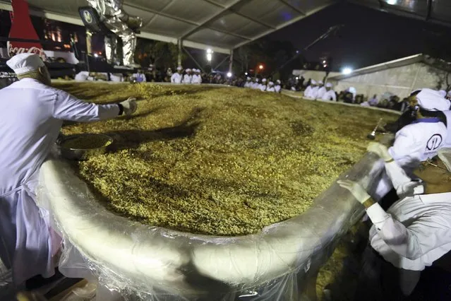 Workers prepare Koshary, a popular Egyptian dish, in an attempt to break the Guinness World Record for the world's biggest plate of Koshary, at a general garden in Zamalek, Cairo, January 17, 2015. (Photo by Mohamed Abd El Ghany/Reuters)
