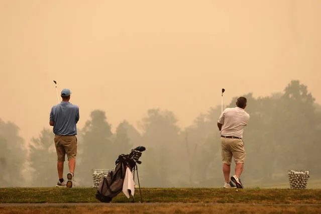 Golfers watch their shots at the driving range at Valley Country Club in Sugarloaf, Pa., as smoke from wildfires in Canada fill the air, Wednesday June 7, 2023. (Photo by John Haeger/Standard-Speaker via AP Photo)