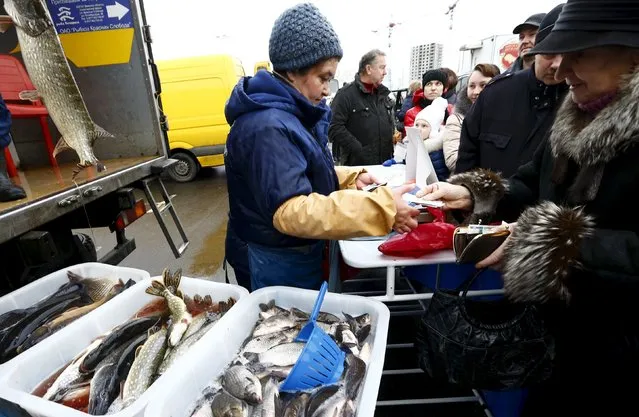 People buy fish at a street market during a food fair in Minsk, Belarus December 19, 2015. (Photo by Vasily Fedosenko/Reuters)
