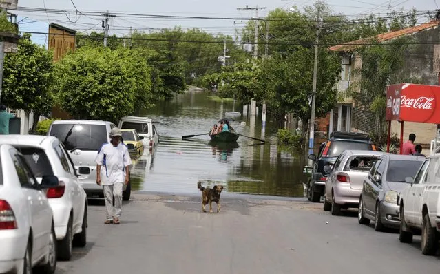 People travel on a boat near flood-affected houses in Asuncion, December 27, 2015. (Photo by Jorge Adorno/Reuters)