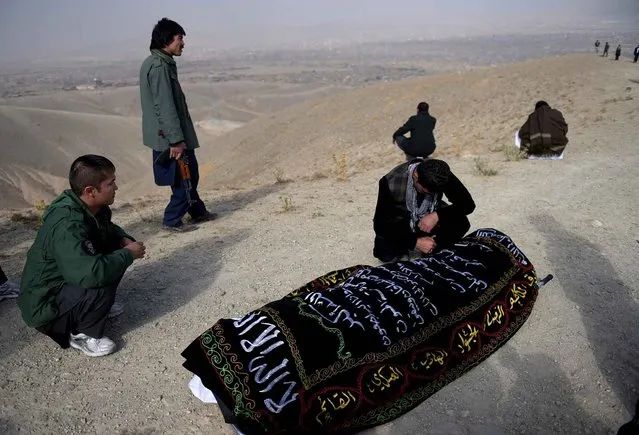 A relative weeps next to the coffin of one of the 27 victims killed in a bloody mosque bombing, in Kabul on November 23, 2016. An international rights group and victims' families urged the Afghan government on November 22 to protect the minority Shiite community after a bloody mosque bombing, the latest in a series of deadly sectarian attacks. A massive suicide blast claimed by the Islamic State group targeted a Shiite congregation in Kabul on November 22, killing at least 27 people and wounding 64. (Photo by Shah Marai/AFP Photo)