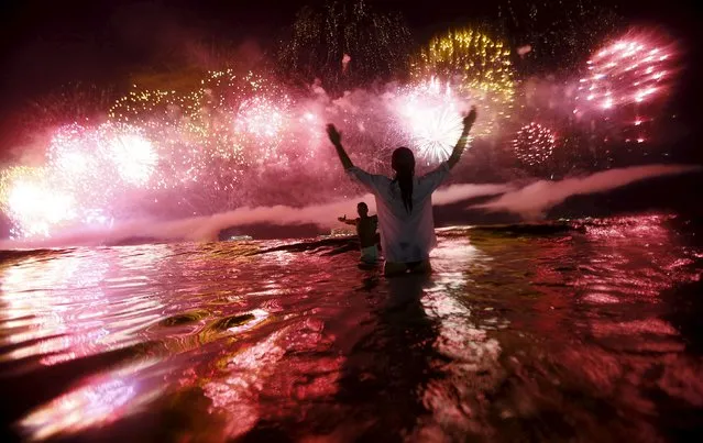 A couple watch as fireworks explode over Copacabana beach during New Year celebrations in Rio de Janeiro, Brazil, January 1, 2016. (Photo by Ricardo Moraes/Reuters)