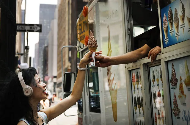 A woman buys and ice cream cone on a hot afternoon in Manhattan on August 6, 2018 in New York City. New York City is enduring another day of intense heat with temperatures in the 90's and high humidity levels. Area beaches and pools have been experiencing large crowds as New Yorkers look for opportunities to stay cool. (Photo by Spencer Platt/Getty Images)