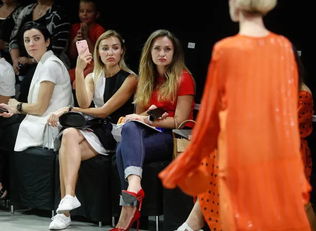 Visitors look on a model who presents a creation by Ukrainian brand A.M.G.during the Ukrainian Fashion Week in Kiev, Ukraine, 01 September 2018. (Photo by Sergey Dolzhenko/EPA/EFE)