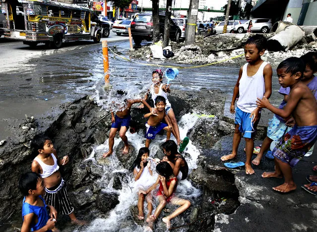 Children take advantage of a busted water pipe which was damaged overnight by a construction company as they take a bath Thursday, October 3, 2013 at suburban Quezon city northeast of Manila, Philippines. (Photo by Bullit Marquez/AP Photo)