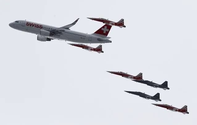 Members of the Swiss aerobatic team Patrouille Swiss fly in formation with a Swiss Airbus A 320 over the men's Alpine Skiing World Cup Super Combined in Wengen January 16, 2015. (Photo by Ruben Sprich/Reuters)