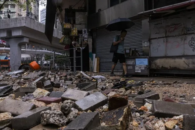 A pedestrian passes through debris following heavy rainstorms in Hong Kong, Friday, September 8, 2023. (Photo by Louise Delmotte/AP Photo)