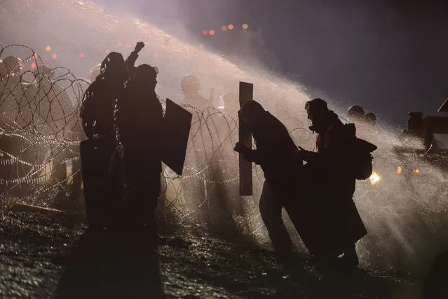 Police use a water cannon on protesters during a protest against plans to pass the Dakota Access pipeline near the Standing Rock Indian Reservation, near Cannon Ball, North Dakota, November 20, 2016. (Photo by Stephanie Keith/Reuters)