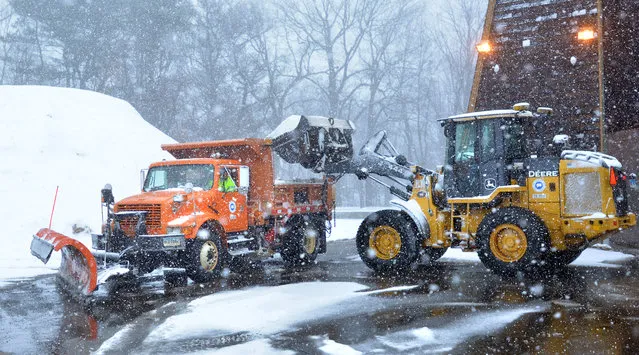 A plow fills up with salt at the Guilford Department of Transporation headquarters during the stormstorm in Guilford, Conn., Saturday, January 23, 2016. A massive winter storm buried much of the U.S. East Coast in a foot or more of snow by Saturday, shutting down transit in major cities, stranding drivers on snowbound highways, knocking out power to tens of thousands of people. (Photo by Peter Casolino/The Hartford Courant via AP Photo)