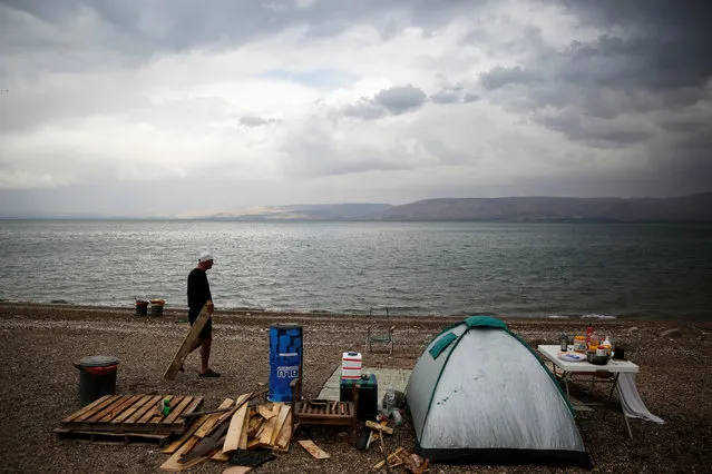A man walks near his camp site on the shore of the Sea of Galilee near Tiberias, Israel December 1, 2016. (Photo by Ronen Zvulun/Reuters)