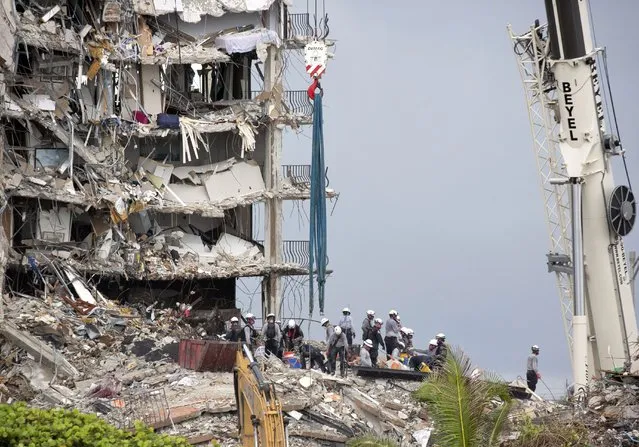 Rescue workers continue to search for survivors in the collapsed building of the Champlain Towers South, Wednesday June 30, 2021, in Surfside, Fla. Crews searching for survivors in the ruins of a collapsed Florida condo tower have built a ramp that should allow the use of heavier equipment, potentially accelerating the removal of concrete that “could lead to incredibly good news events”, the state fire marshal said Wednesday. (Photo by Emily Michot/Miami Herald via AP Photo)