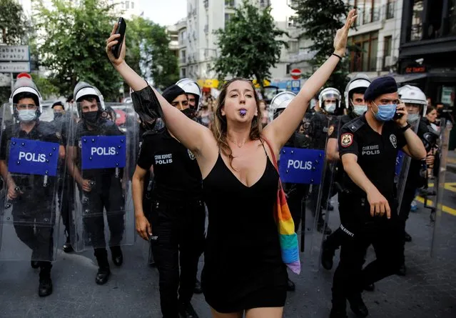 Liana Georgi blows her whistle as riot police try to disperse her and others gathering for a Pride parade, which was banned by local authorities, in central Istanbul, Turkey on June 26, 2021. (Photo by Umit Bektas/Reuters)