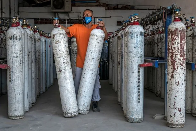 A worker arranges oxygen tanks for hospitals at an oxygen distribution facility on July 07, 2021 in Yogyakarta, Indonesia. Indonesia on Tuesday reported a record 31,189 locally transmitted Covid-19 cases, and 728 recorded fatalities, a worrying spike as a new wave of the coronavirus gathered pace. (Photo by Ulet Ifansasti/Getty Images)