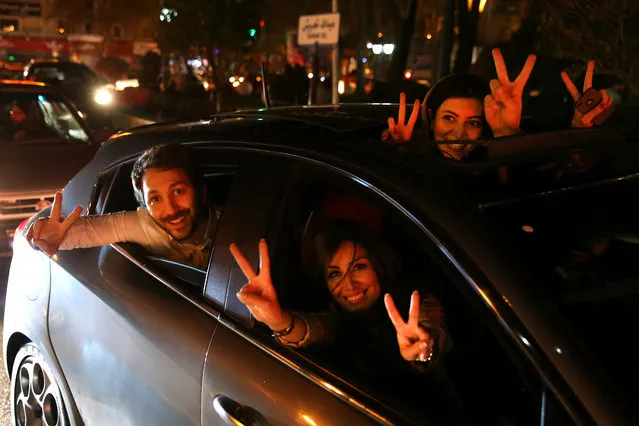 Iranians flash the victory sign from their car while celebrating on a street in northern Tehran, Iran, Thursday, April 2, 2015, after Iran's nuclear agreement with world powers in Lausanne, Switzerland. (Photo by Ebrahim Noroozi/AP Photo)