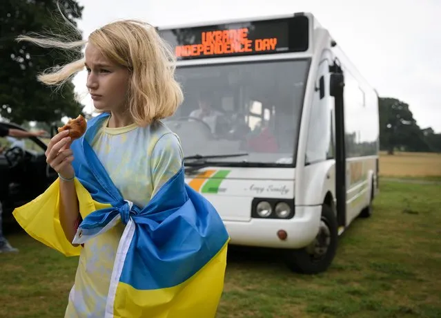 Caryna Siebienkova eats a biscuit as a passenger bus arrives at the Ukrainian Independence Day - Family Event put on by Exeter Conversation Cafe at Poltimore House, on August 24, 2022 in Exeter, England. (Photo by Finnbarr Webster/Getty Images)