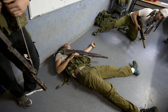 In this Tuesday, March 24, 2015 photo, Israeli high-school seniors preparing to join the Israeli military participate in an urban fighting drill as part of privately run military combat fitness training, in Kibbutz Mizra, northern Israel. (Photo by Oded Balilty/AP Photo)