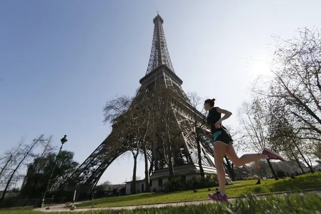 A jogger enjoys a run near the Eiffel Tower on a warm and sunny day in Paris April 8, 2015. (Photo by Gonzalo Fuentes/Reuters)