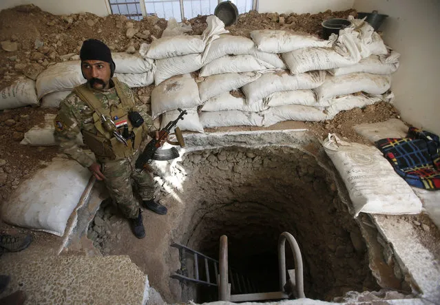 A member of the Iraqi security forces stands next to a tunnel used by Islamic State militants during battle with Islamic State militants in Talkeef district north of Mosul, Iraq, January 20, 2017. (Photo by Khalid al Mousily/Reuters)