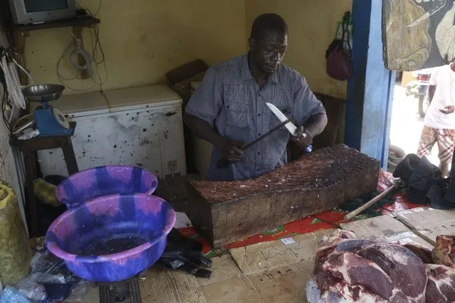 A man sells meat on a street in Conakry, Guinea, Thursday, September 9, 2021. Guinea's new military leaders sought to tighten their grip on power after overthrowing President Alpha Conde, warning local officials that refusing to appear at a meeting convened Monday would be considered an act of rebellion against the junta. (Photo by Sunday Alamba/AP Photo)