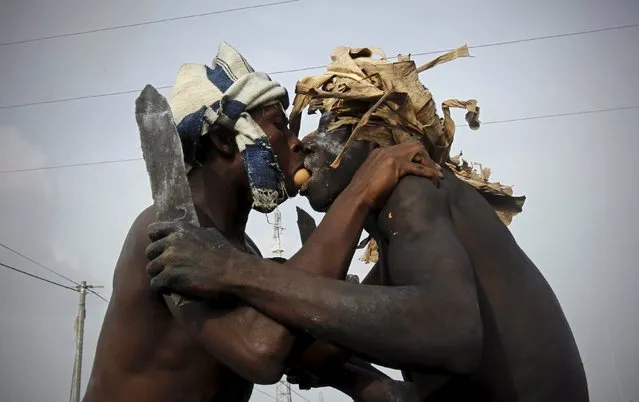 Participants pass an egg using their mouths during a religious ritual as they play the role of traditional fighters in a parade during the Popo (Mask) Carnival of Bonoua, in the east of Abidjan, April 18, 2015. The carnival has its origins in the changes that Aboure youths in Bonoua introduced to the annual festival of yams. (Photo by Luc Gnago/Reuters)