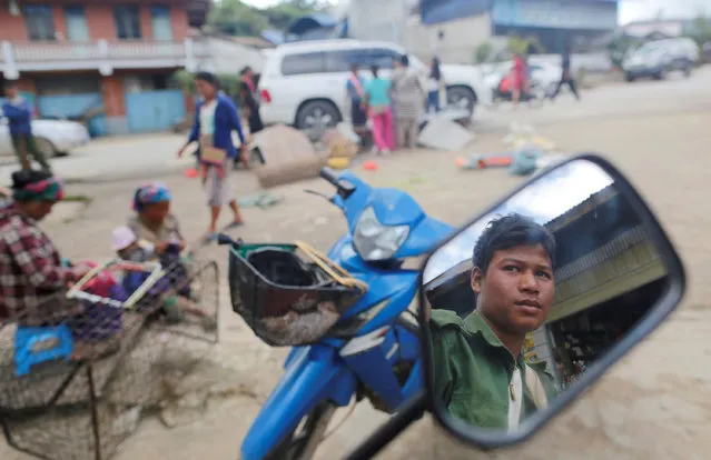 A United Wa State Army (UWSA) soldier reflected on mirror as he sits on a motorbike in a market at Mongmao, Wa territory in northeast Myanmar October 1, 2016. (Photo by Soe Zeya Tun/Reuters)
