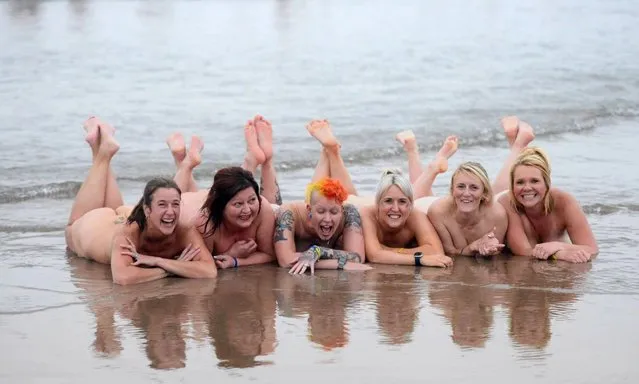Participants in the annual North East Skinny Dip walk the beach in Druridge Bay, Northumberland, United Kingdom on September 19, 2021. (Photo by Newcastle New Projects)