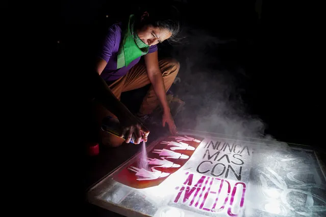 A demonstrator spray paints stencils on Constitution Square during a march on International Women's Day in Mexico City, Mexico, March 8, 2019. (Photo by Toya Sarno Jordan/Reuters)