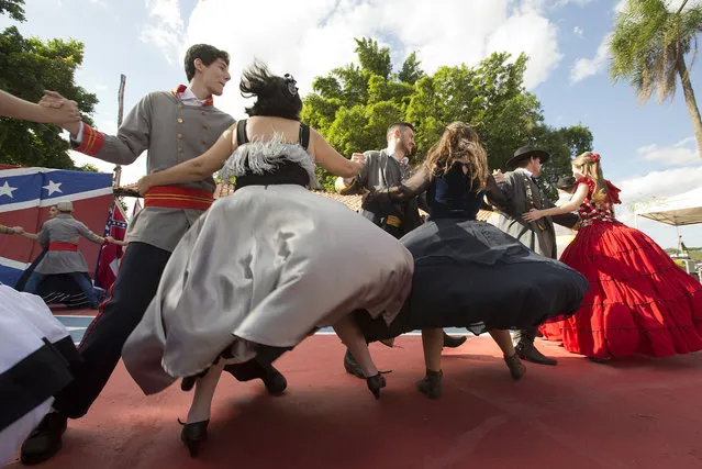 Descendants of American Southerners Wearing Confederate-era dresses and uniforms dance during a party to celebrate the 150th anniversary of the end of the American Civil War in Santa Barbara d'Oeste, Brazil, Sunday, April 26, 2015. For many of the residents of Santa Barbara d'Oeste and neighboring Americana, in Brazil's southeastern Sao Paulo state. (Photo by Andre Penner/AP Photo)