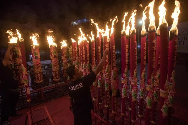 An Indonesian ethnic Chinese man lights joss sticks during the Lunar New Year celebration at a temple in Medan, North Sumatra, Indonesia, early Saturday, February 10, 2024. Chinese around the globe are celebrating Lunar New Year that marks the year of the dragon on the Chinese calendar this year. (Photo by Binsar Bakkara/AP Photo)
