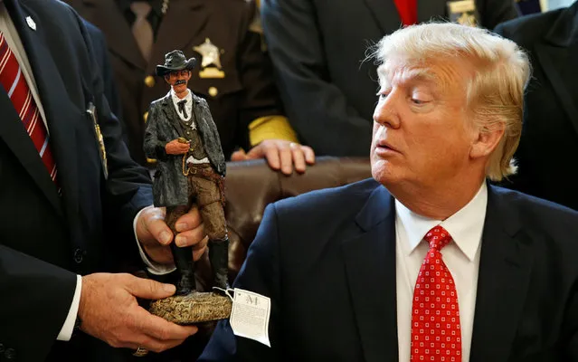 U.S. President Donald Trump receives a figurine of a sheriff during a meeting with county sheriffs at the White House in Washington, U.S. February 7, 2017. (Photo by Kevin Lamarque/Reuters)