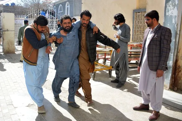 A bomb blast victim (2L) is helped to walk into a hospital in Quetta on February 7, 2024. At least 22 people were killed Wednesday in two separate bomb blasts outside poll candidate offices in southwestern Pakistan, officials said, on the eve of an election marred by violence and allegations of poll-rigging (Photo by AFP Photo)