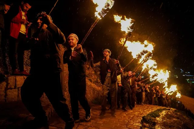 Iraqi Kurds carry fire torches as they celebrate Nowruz Day, a festival marking the first day of spring, Kurdish and Persian New Year in Akre, Iraq on March 20, 2024. Newroz or Nowruz means “new day” in Persian, and is celebrated to mark the arrival of spring and the first day of the Iranian calendar. It is widely celebrated in Persian and neighboring regions and is recognized on UNESCO's Intangible Cultural Heritage of Human List. (Photo by Ismael Adnan/SOPA Images/Rex Features/Shutterstock)