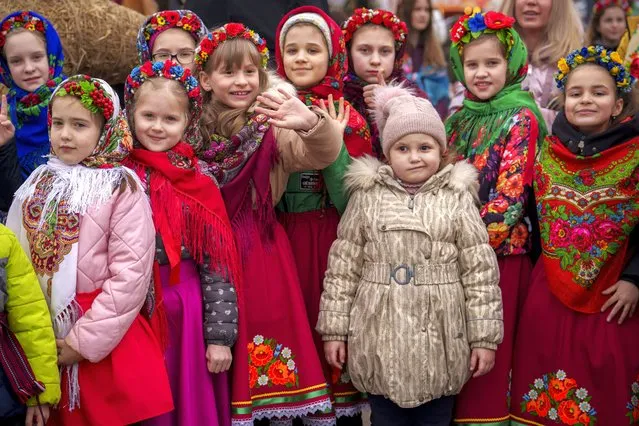 Children wearing traditional outfits wait before performing songs during a show of traditions for Masnytsia, a holiday that originates in pagan times, celebrating the end of winter, in Kyiv, Ukraine, Saturday, March 16, 2024. (Photo by Vadim Ghirda/AP Photo)